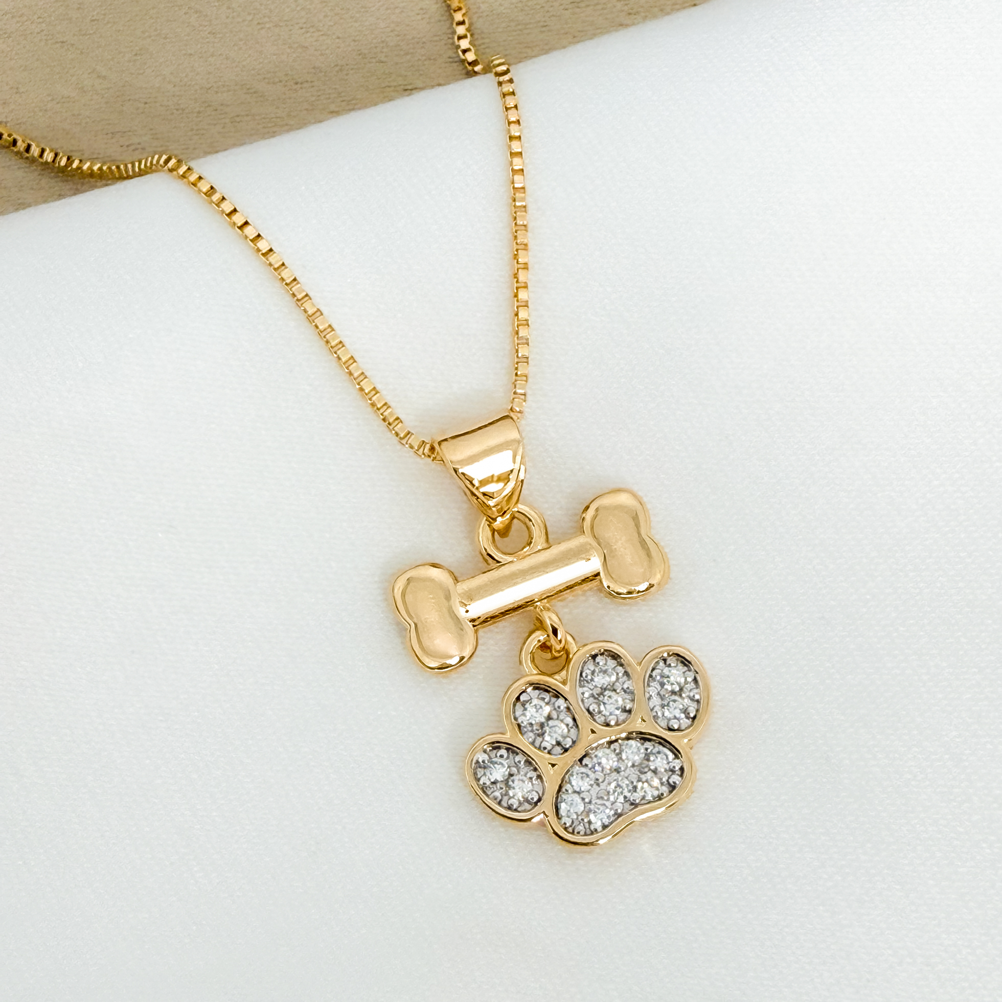 Colar de ossinho com patinha cravejada folheado a ouro 1 Colar de ossinho com patinha cravejada folheado a ouro